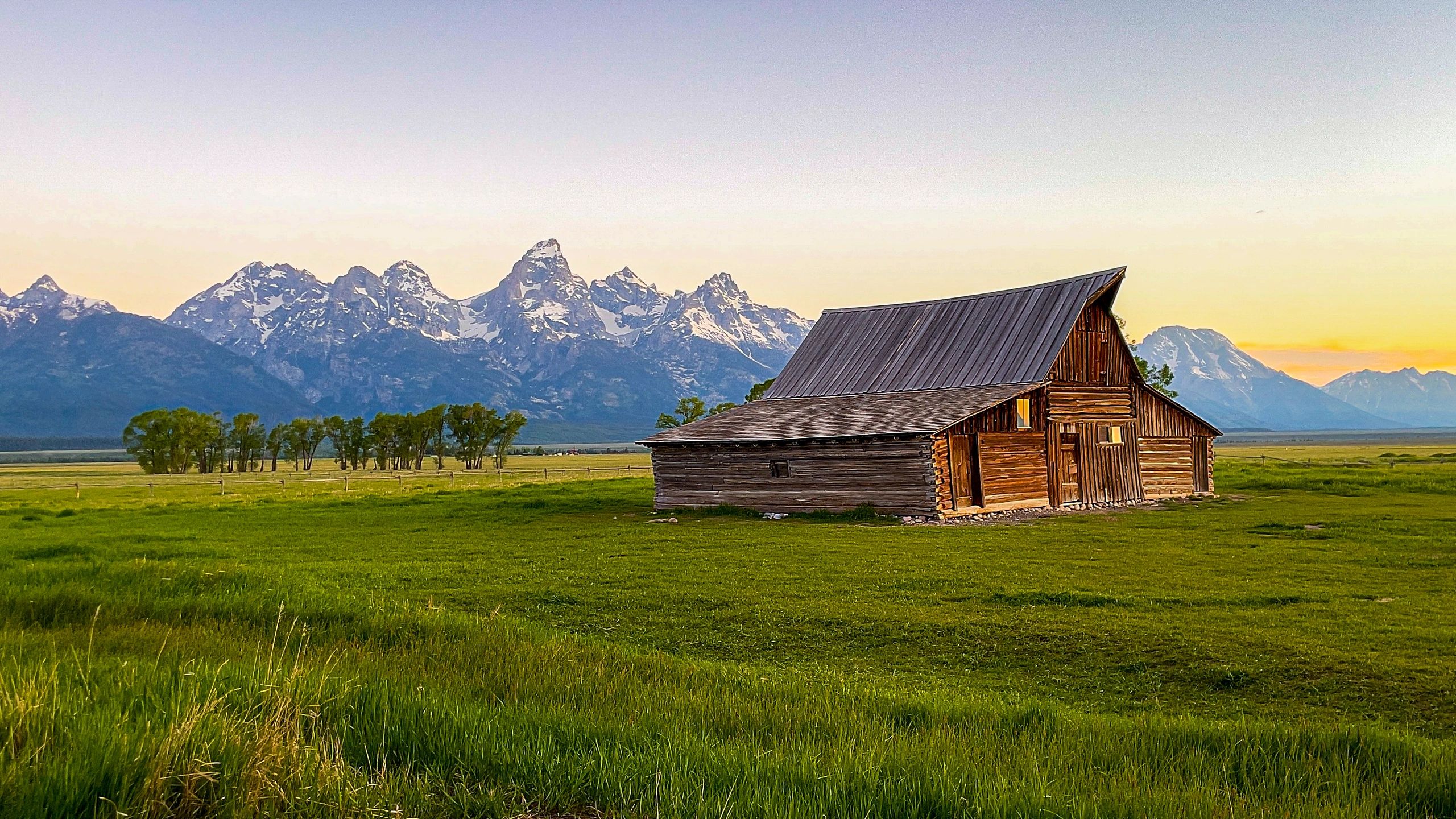 Rustic barn in mountain meadow at golden hour