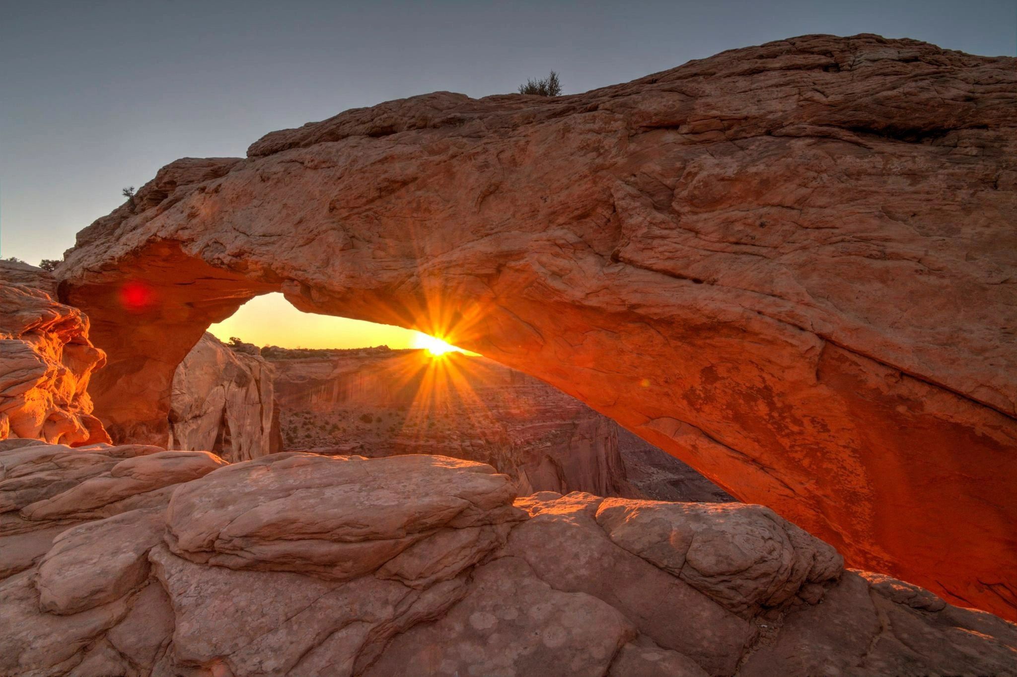 Rock arch formation at sunrise with starburst