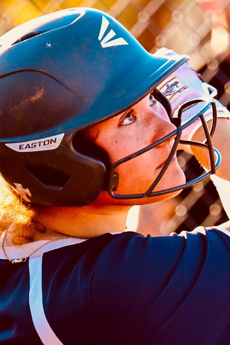 Softball player with batting helmet in action