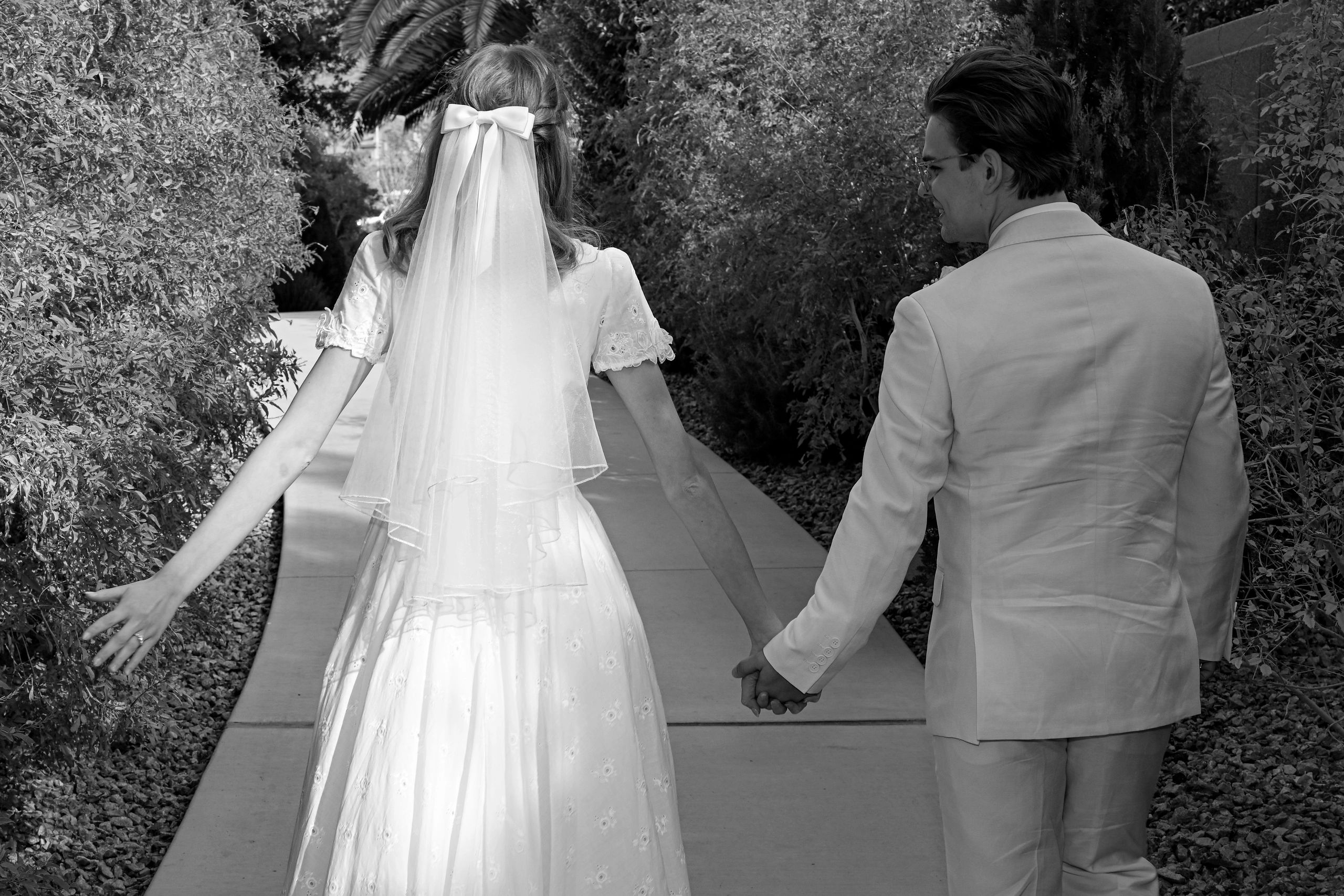 Bride and groom in ivy garden corridor